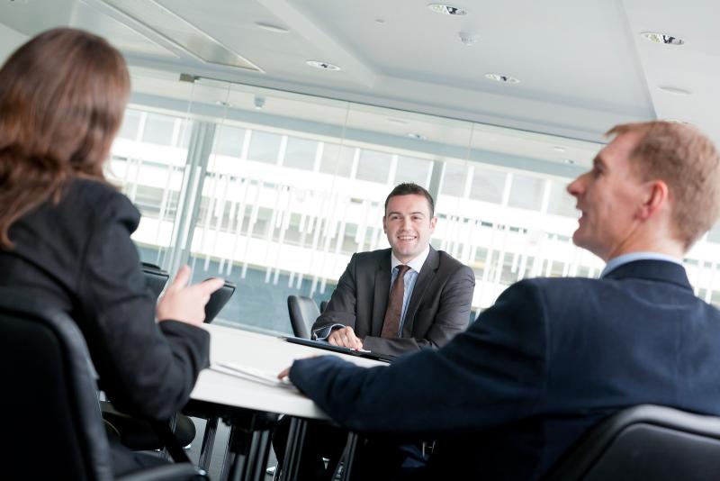 Three people in business attire conducting a interview