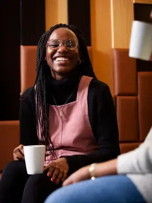 A woman with long braided hair is smiling